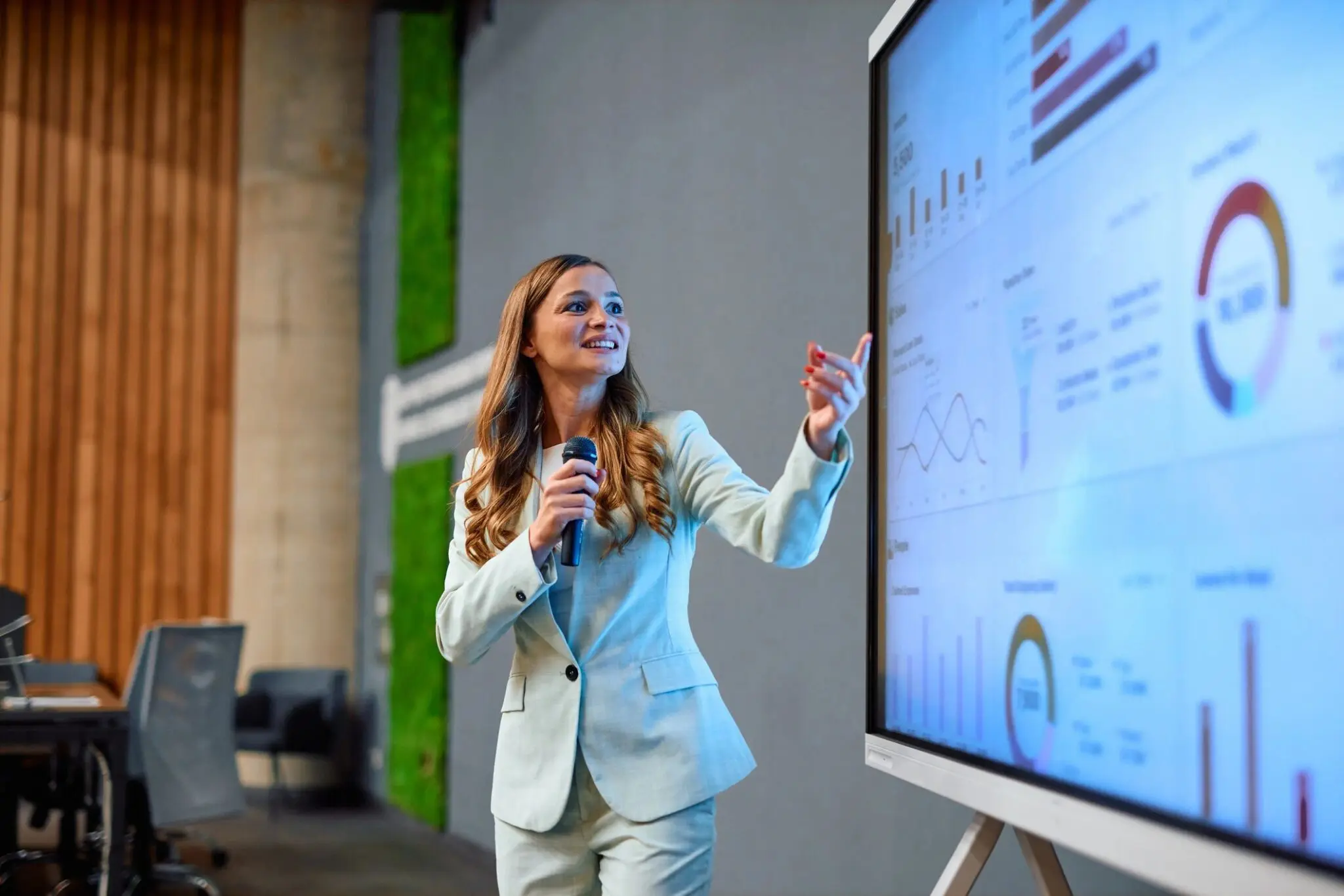 Woman presenting data on a large screen.