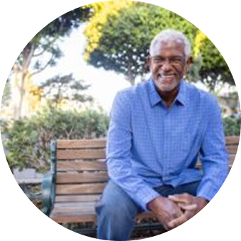 Man smiling while sitting on a bench.
